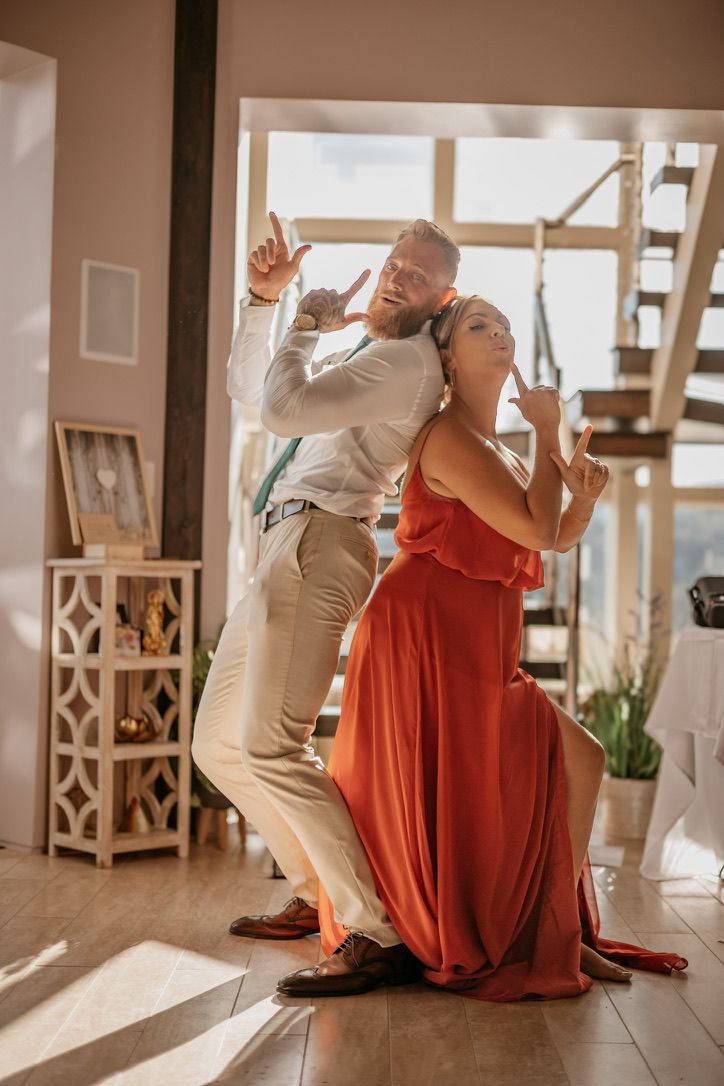Wedding guests sitting on floor in formal attire during indoor celebration.
