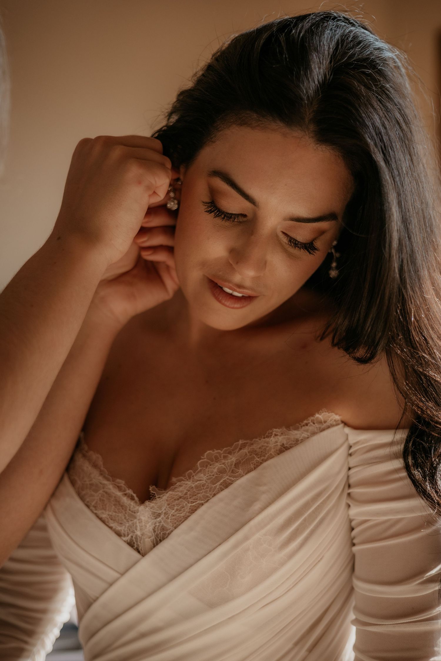 Romantic boudoir photography series featuring delicate white lace details in warm lighting.