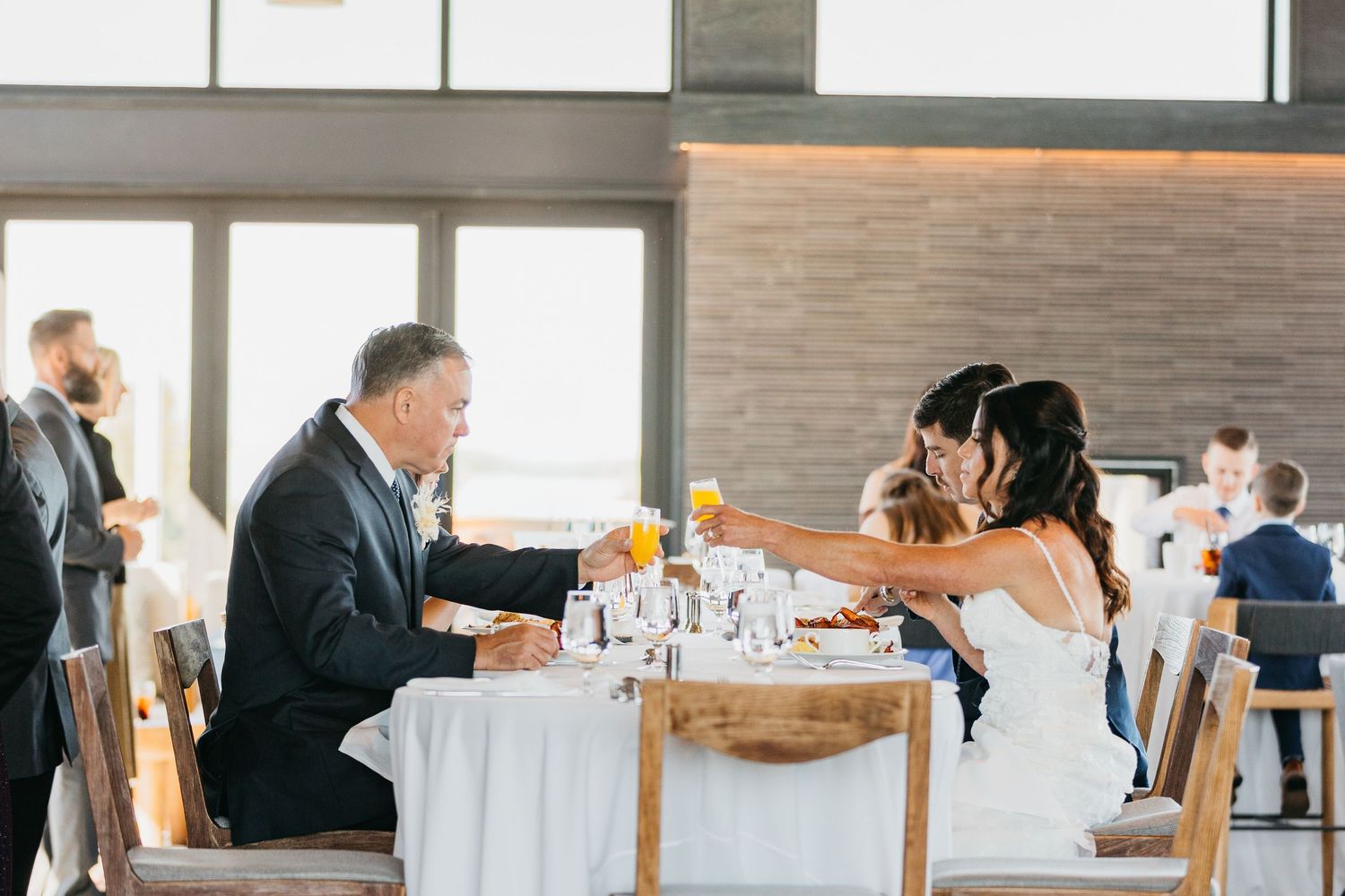 Wedding reception dining room with modern decor and large windows.