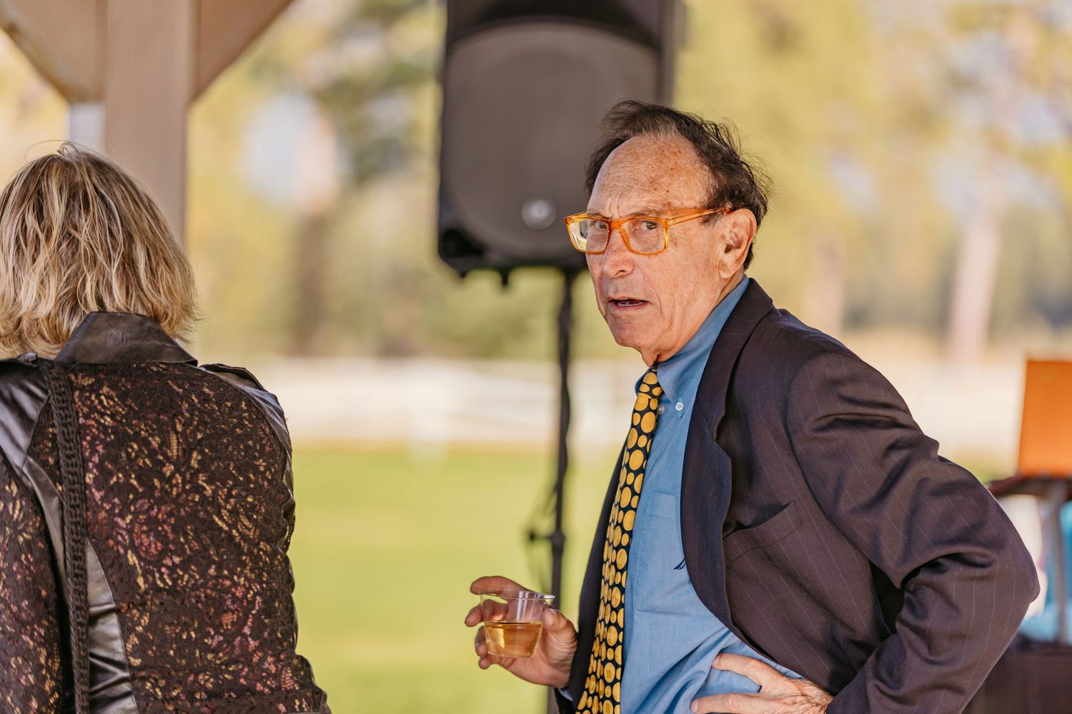 Musicians perform at outdoor wedding with instruments and formal attire.
