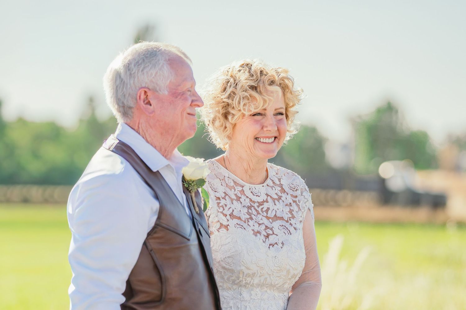 Couple sharing a joyful moment during an outdoor wedding ceremony.