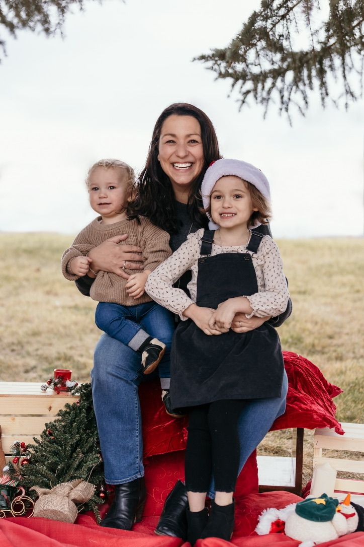 Cozy winter photoshoot with red blanket and holiday decorations.