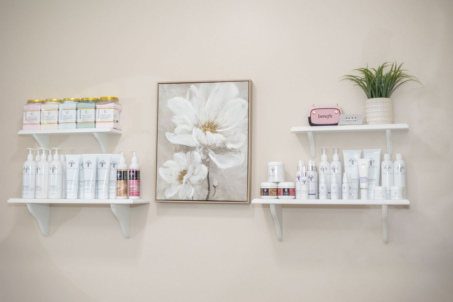 Clean, minimalist spa interior with white shelving displaying beauty products.