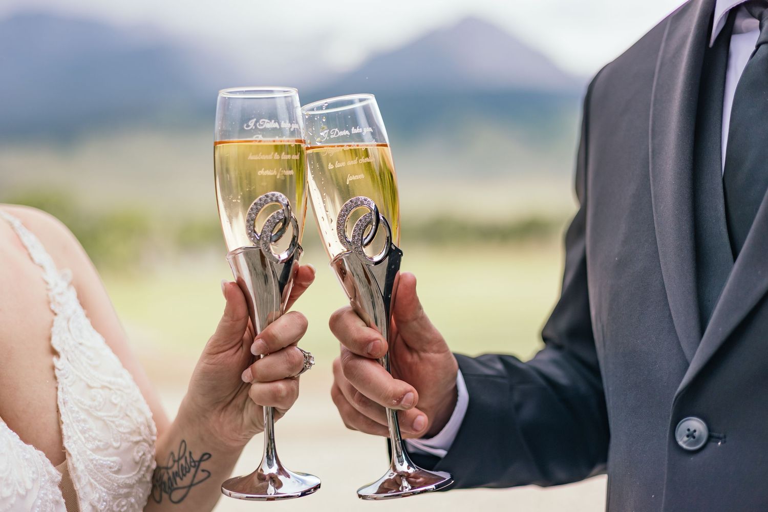 Wedding guests toasting with champagne glasses against a mountain backdrop.