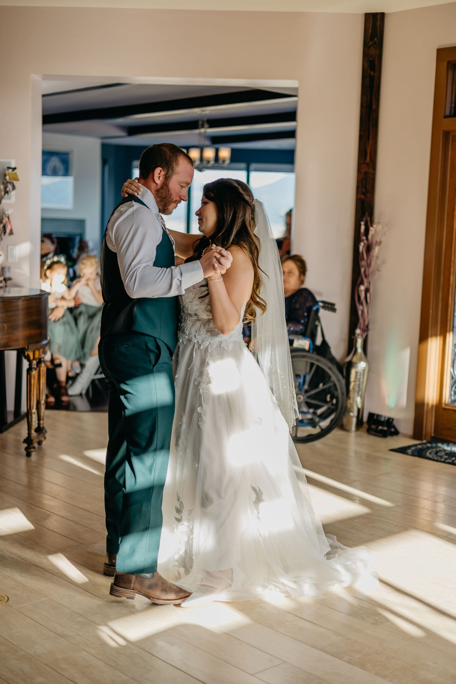 Couple shares a romantic dance in a sunlit room with wooden beams.