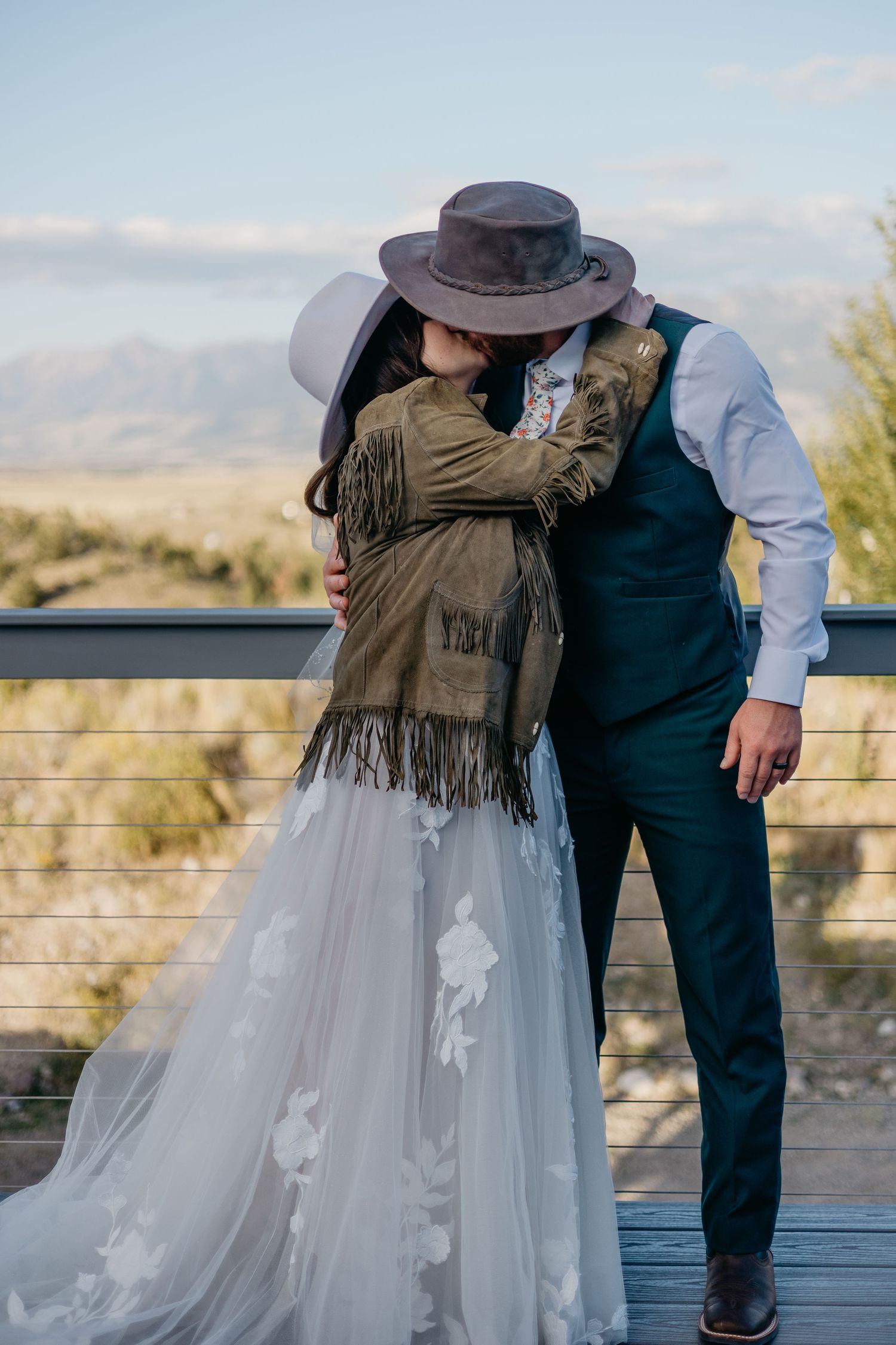 Wedding couple sharing an intimate moment on a deck with mountain views.
