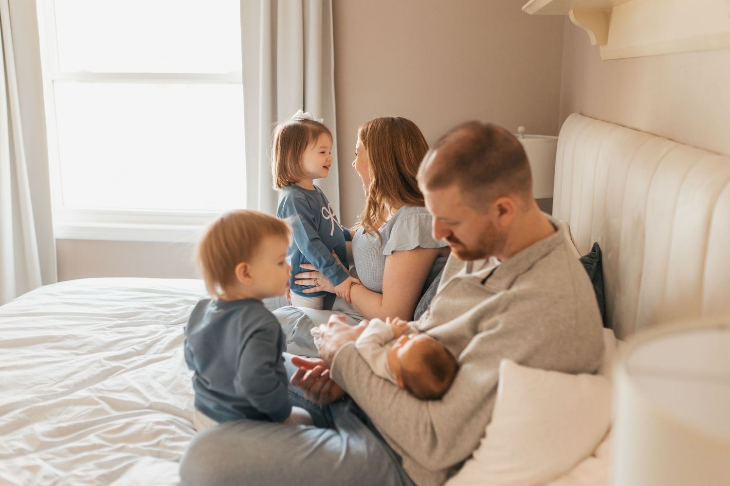 An intimate family gathering on a bed sharing tender moments together.