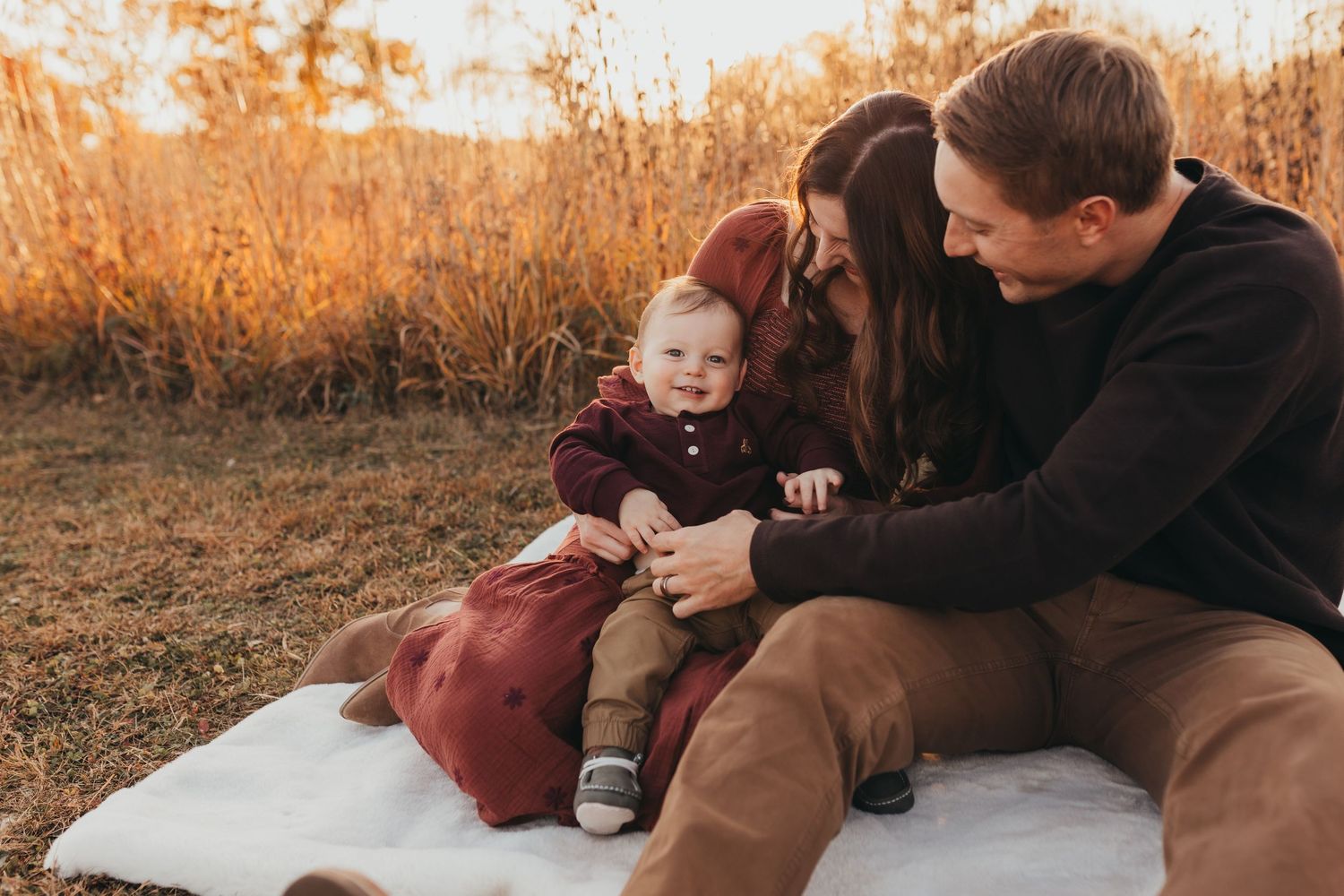 A family enjoys a cozy moment together on a golden autumn evening in an outdoor setting.