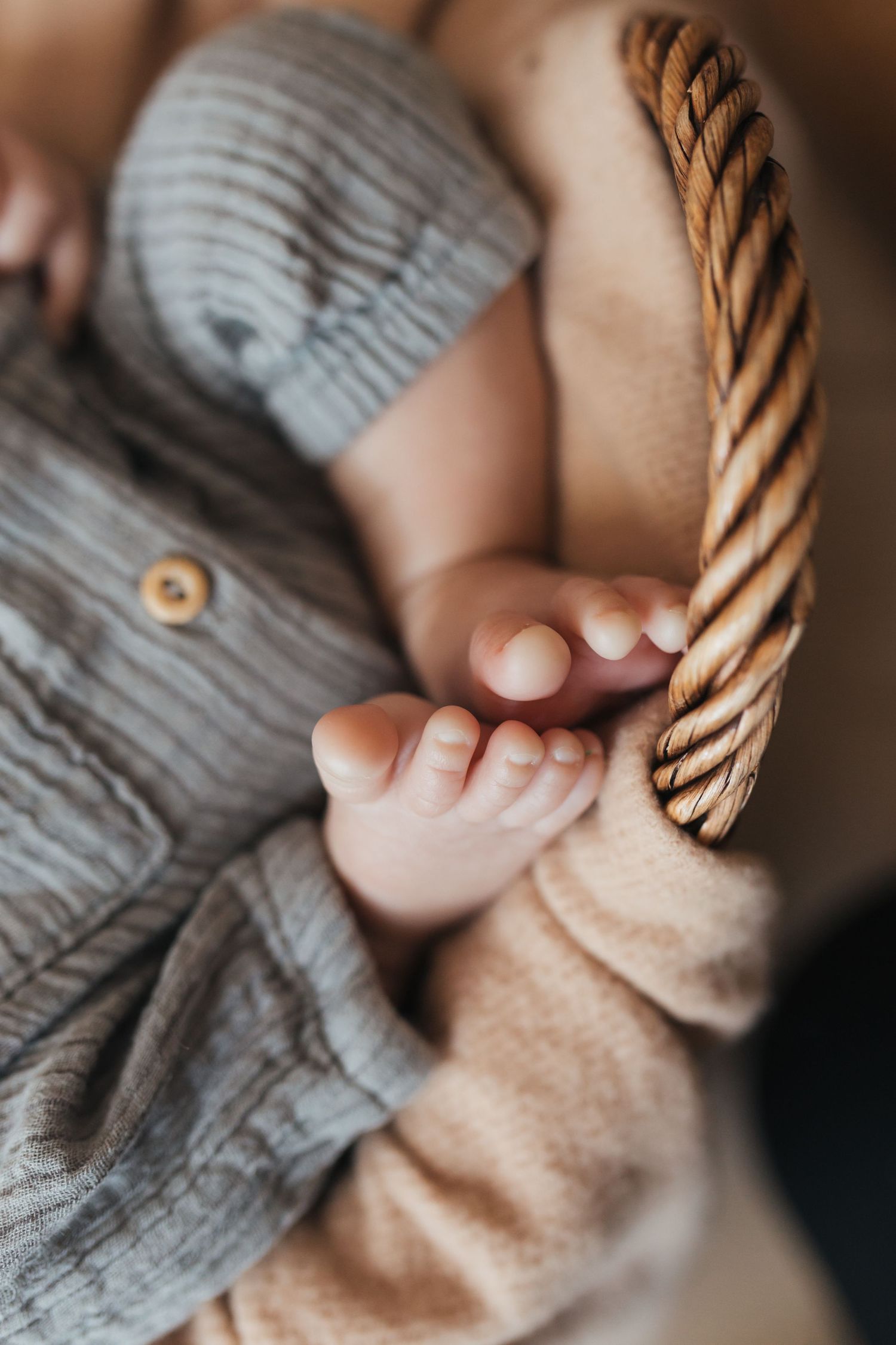 Close-up of tiny baby feet against textured knit blanket.