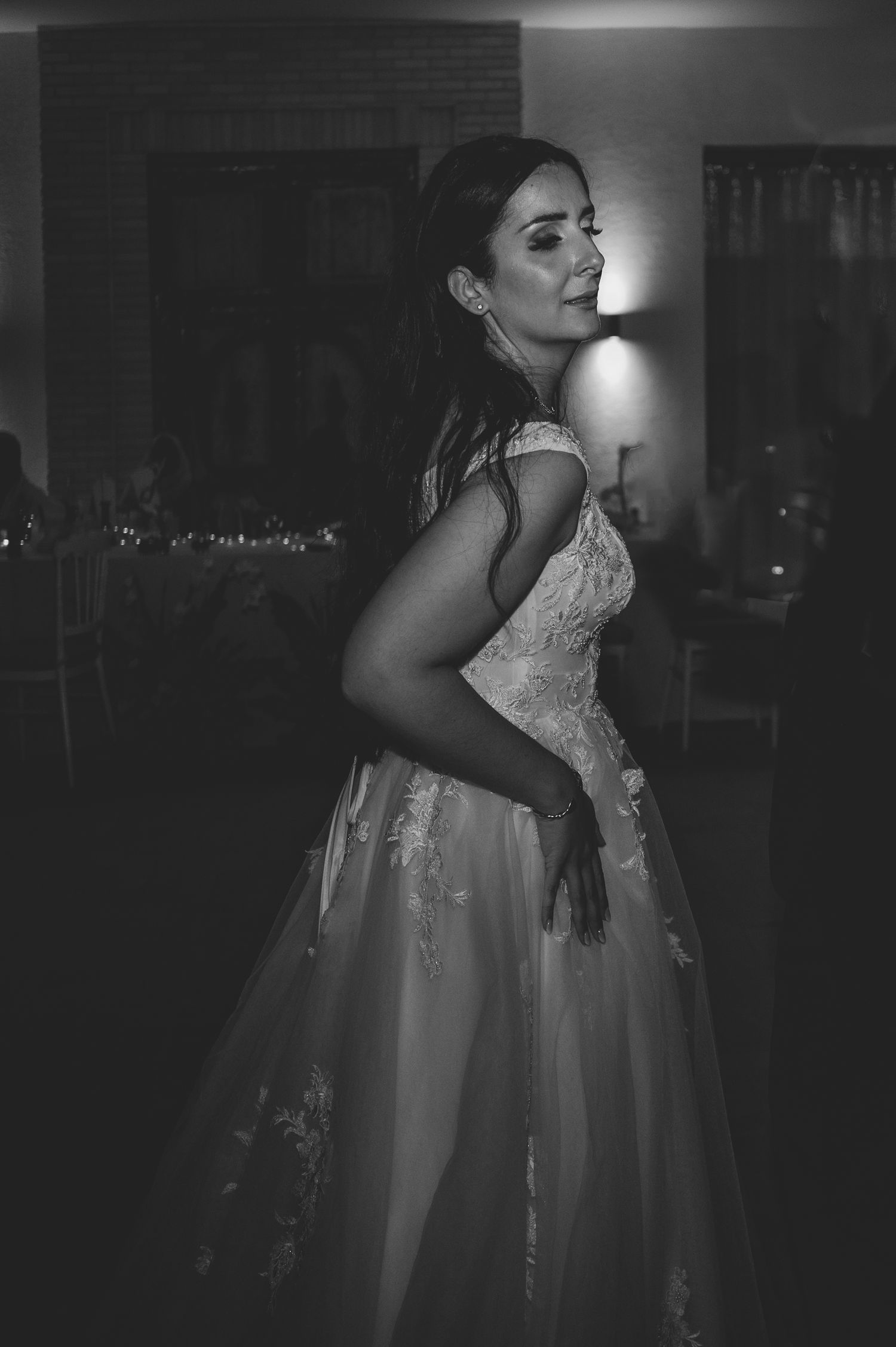 Elegant black and white portrait of a bride in a lace ball gown at her wedding reception.