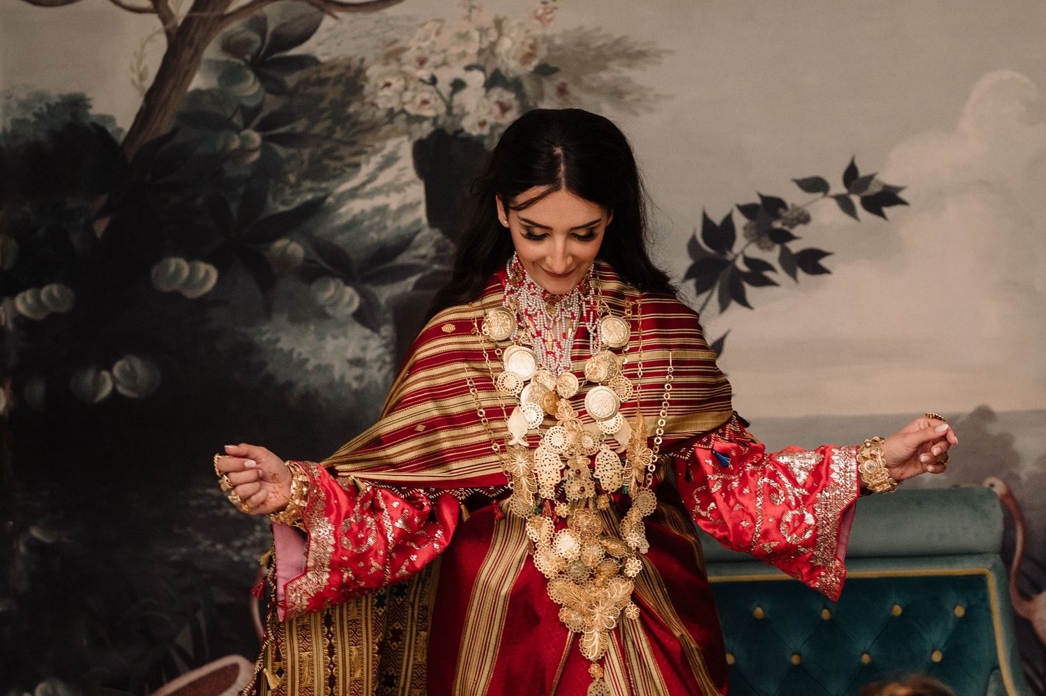 Bride in stunning red and gold traditional South Asian wedding dress with jewelry.