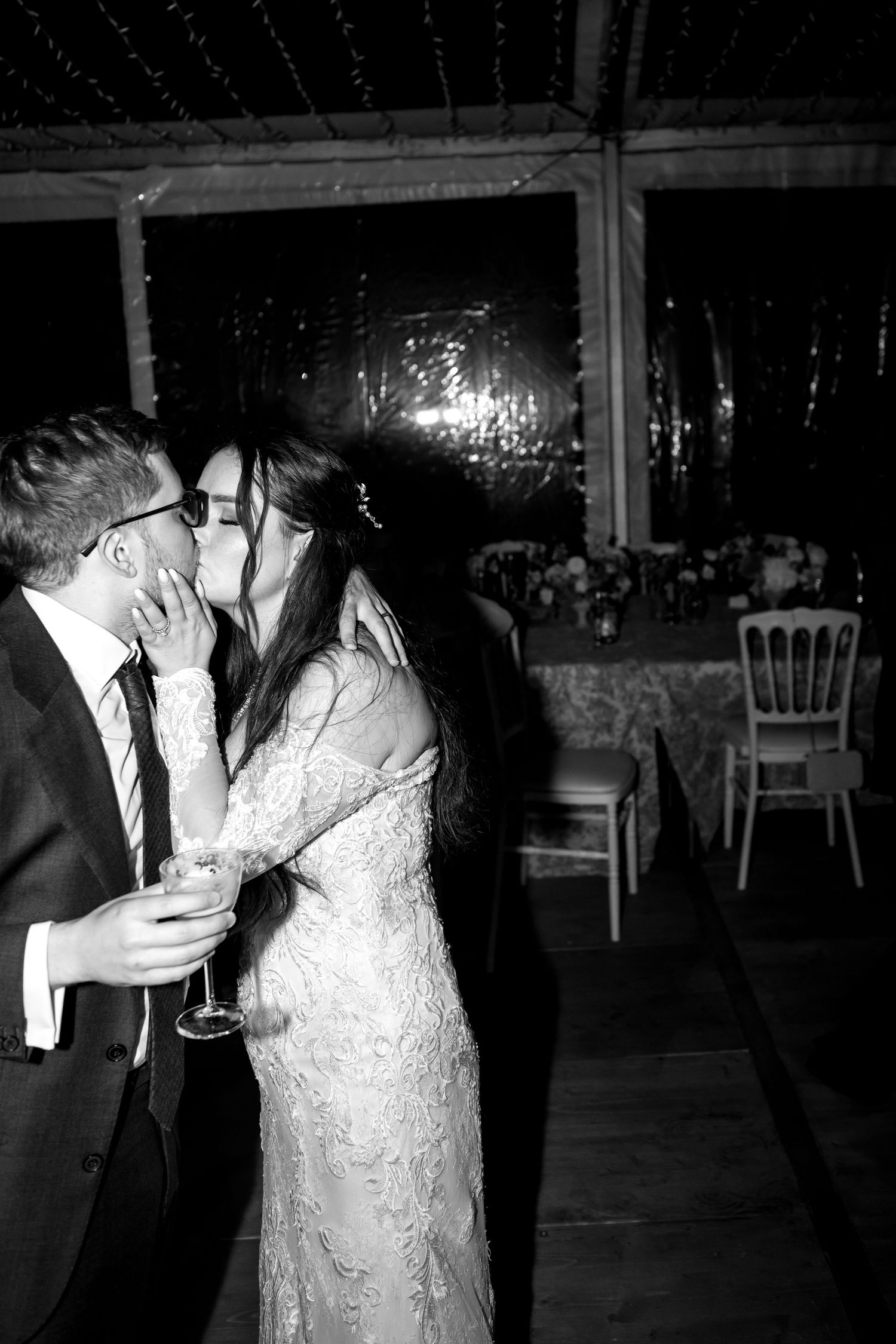 Bride and groom share a kiss on the dance floor at their wedding reception.