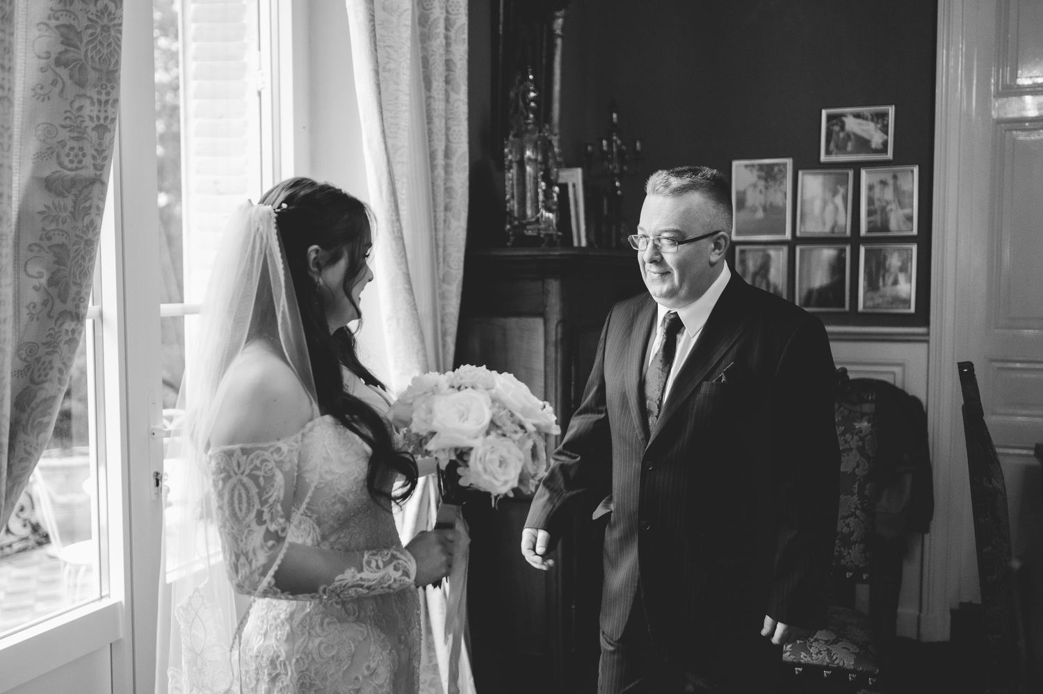 Black and white photo of a bride sharing an emotional first look moment with her father.