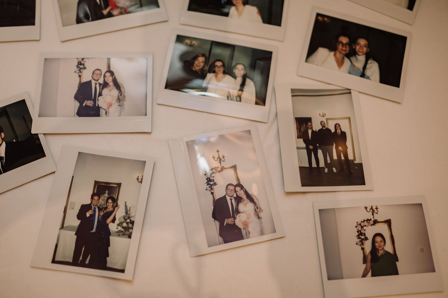Collection of Polaroid instant photos spread on white surface capturing wedding moments.