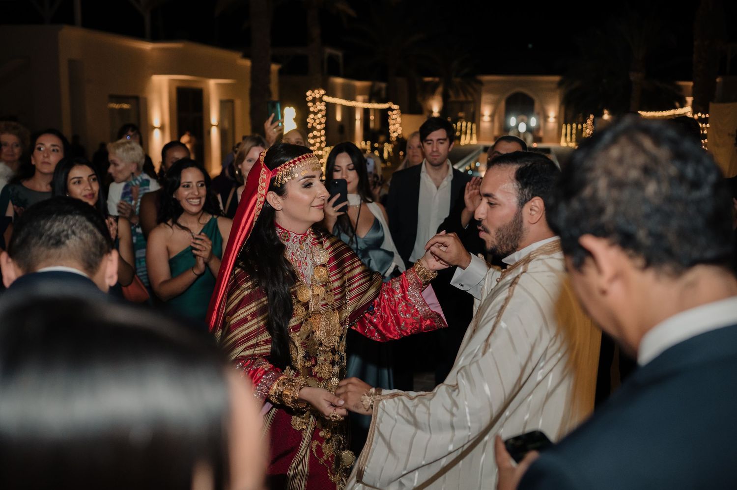 Bride and groom in traditional attire sharing a moment at their wedding reception.