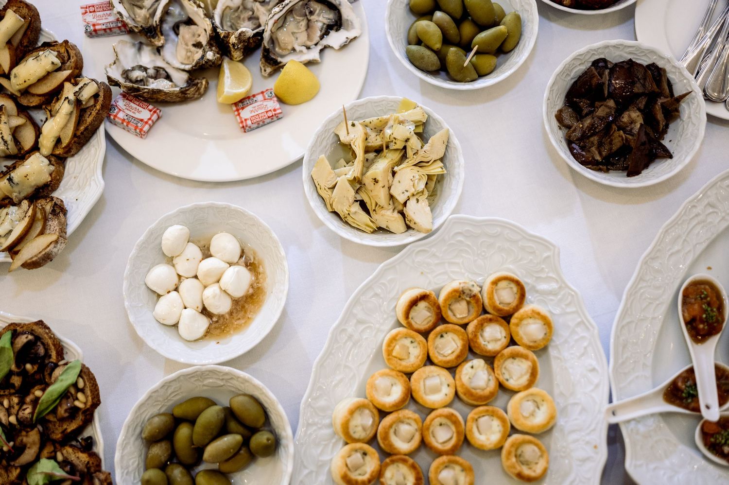 Elegant wedding reception appetizer spread with olives, pastries, and assorted hors d'oeuvres.