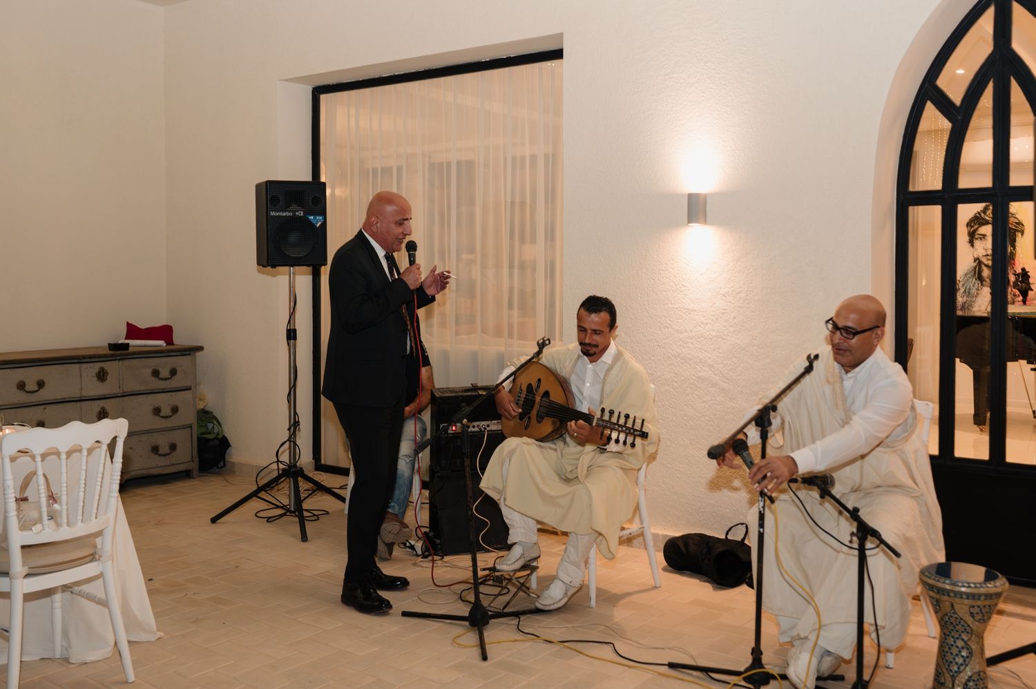 Live band performing at wedding reception with singer and two musicians playing traditional string instruments.