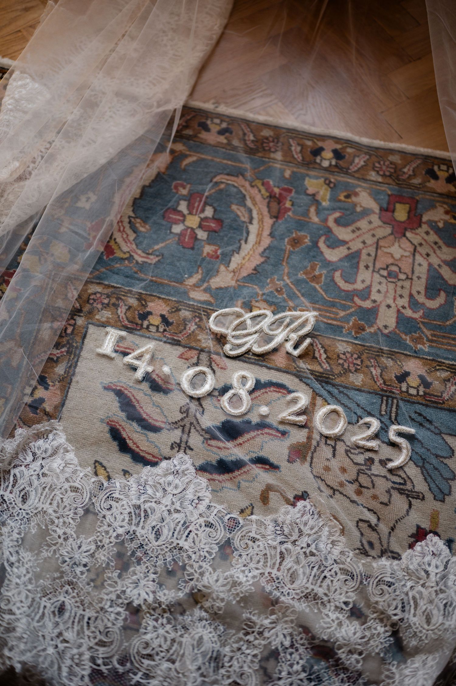 Wedding veil with lace trim on Persian rug showing monogram GR and date 14.08.2025.