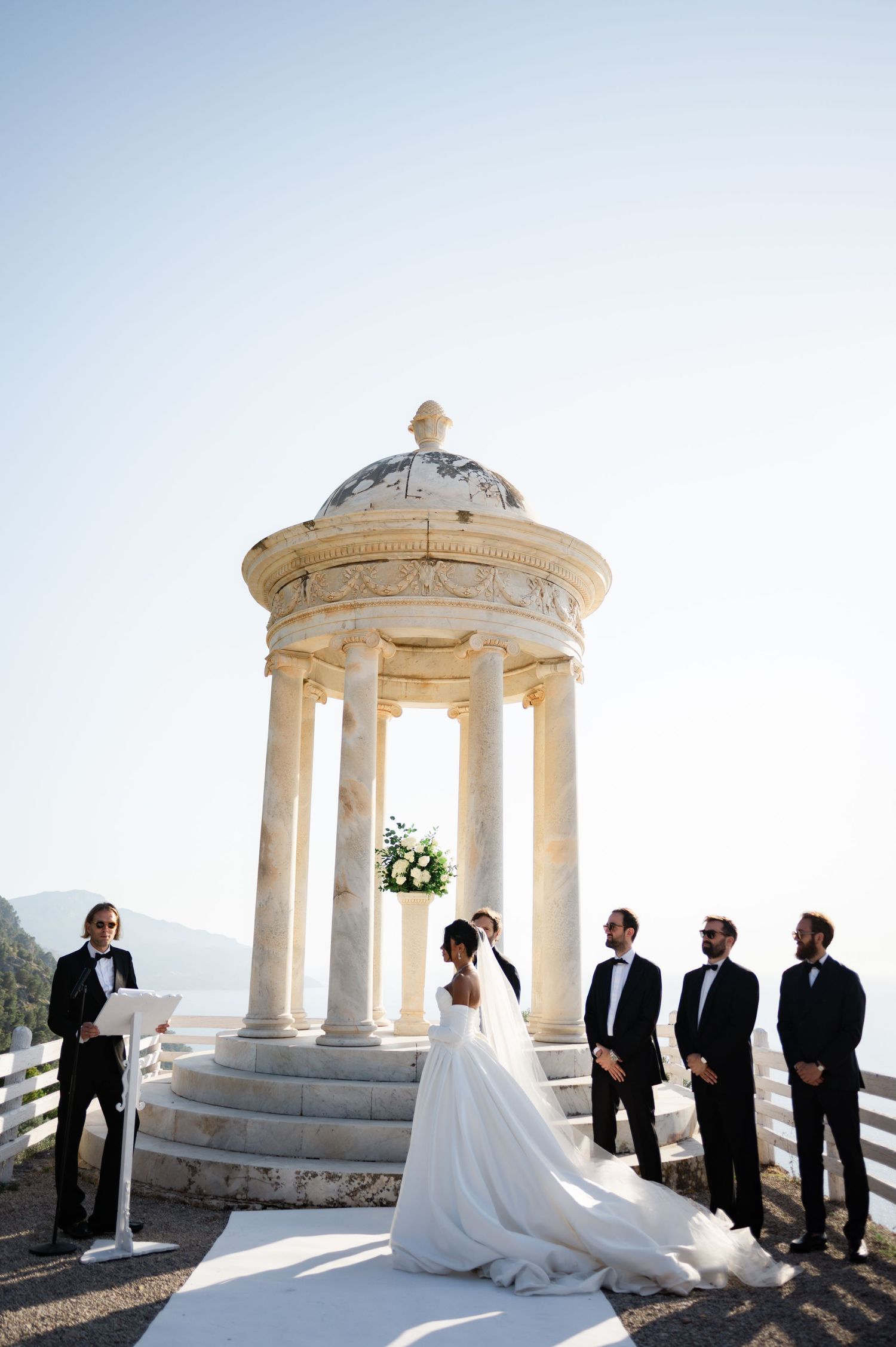 Bride and groom exchange vows at a stunning marble rotunda wedding ceremony with groomsmen and officiant.
