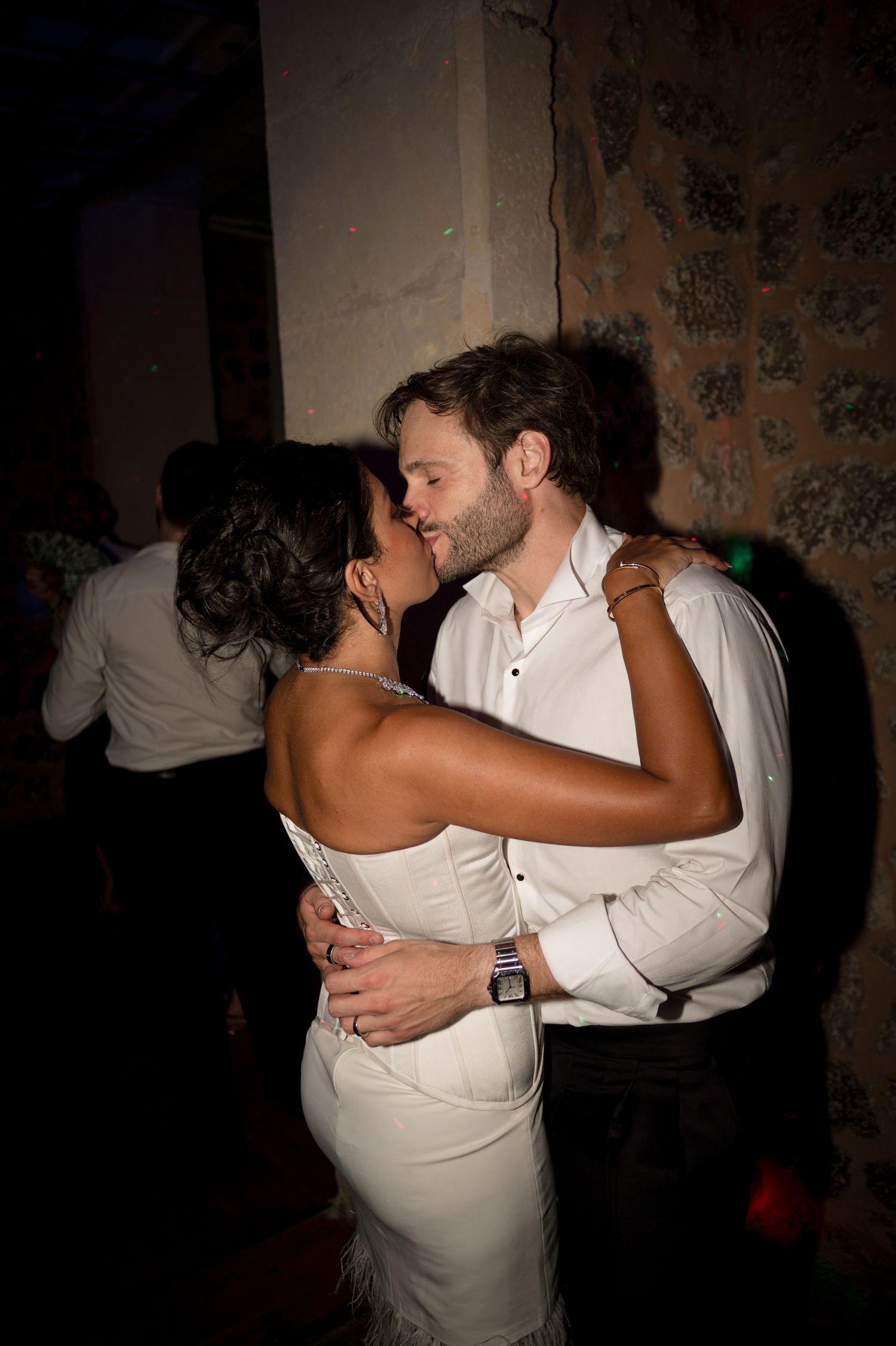 Bride and groom share a romantic kiss on the dance floor at their wedding reception.
