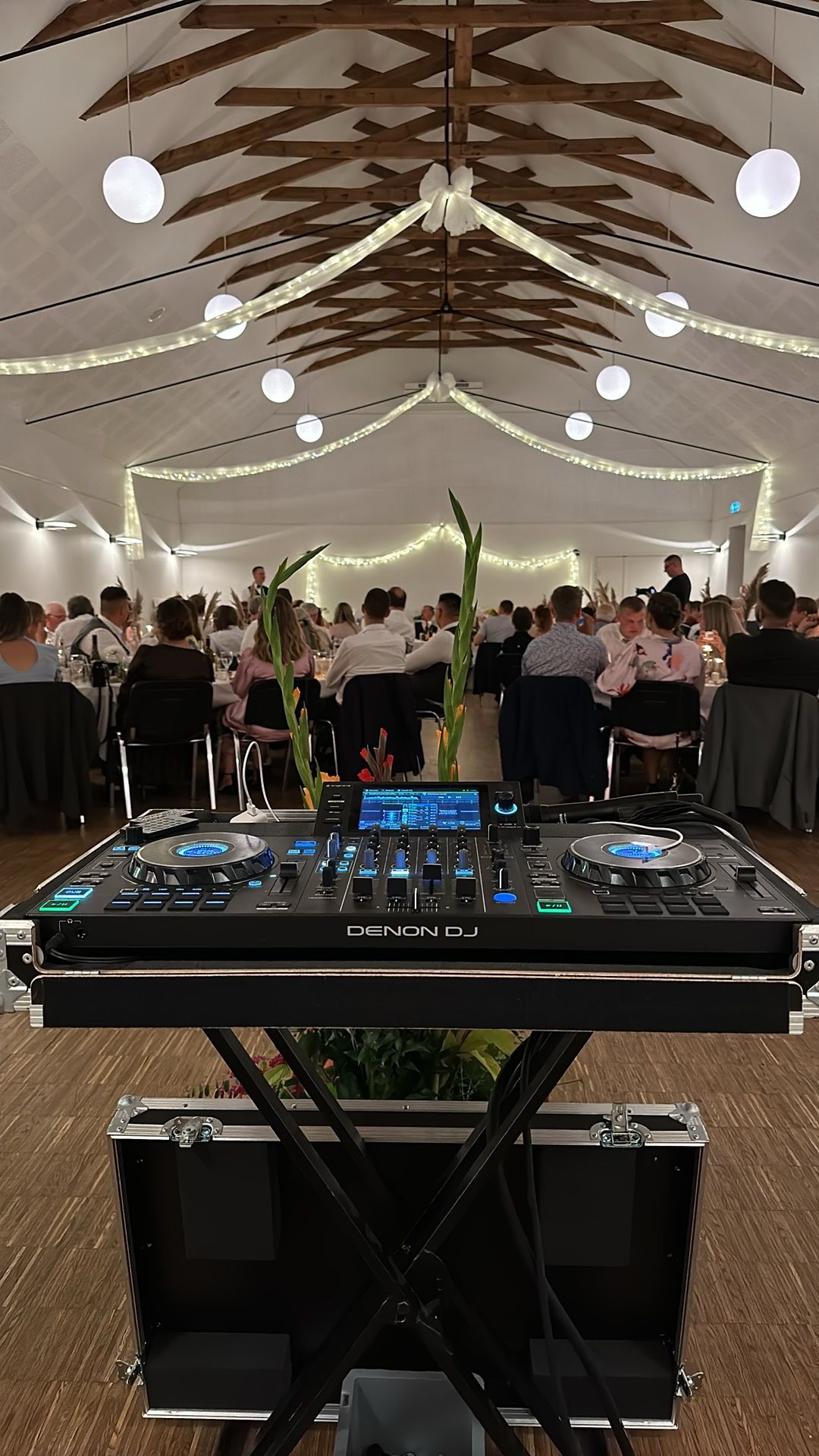 DJ-pult klar til bryllupsfest med gæster i lokalet