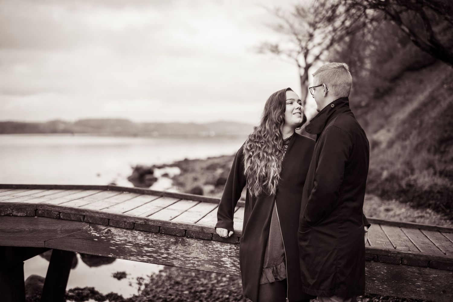 Par fotograferet sammen på stranden ved vandet