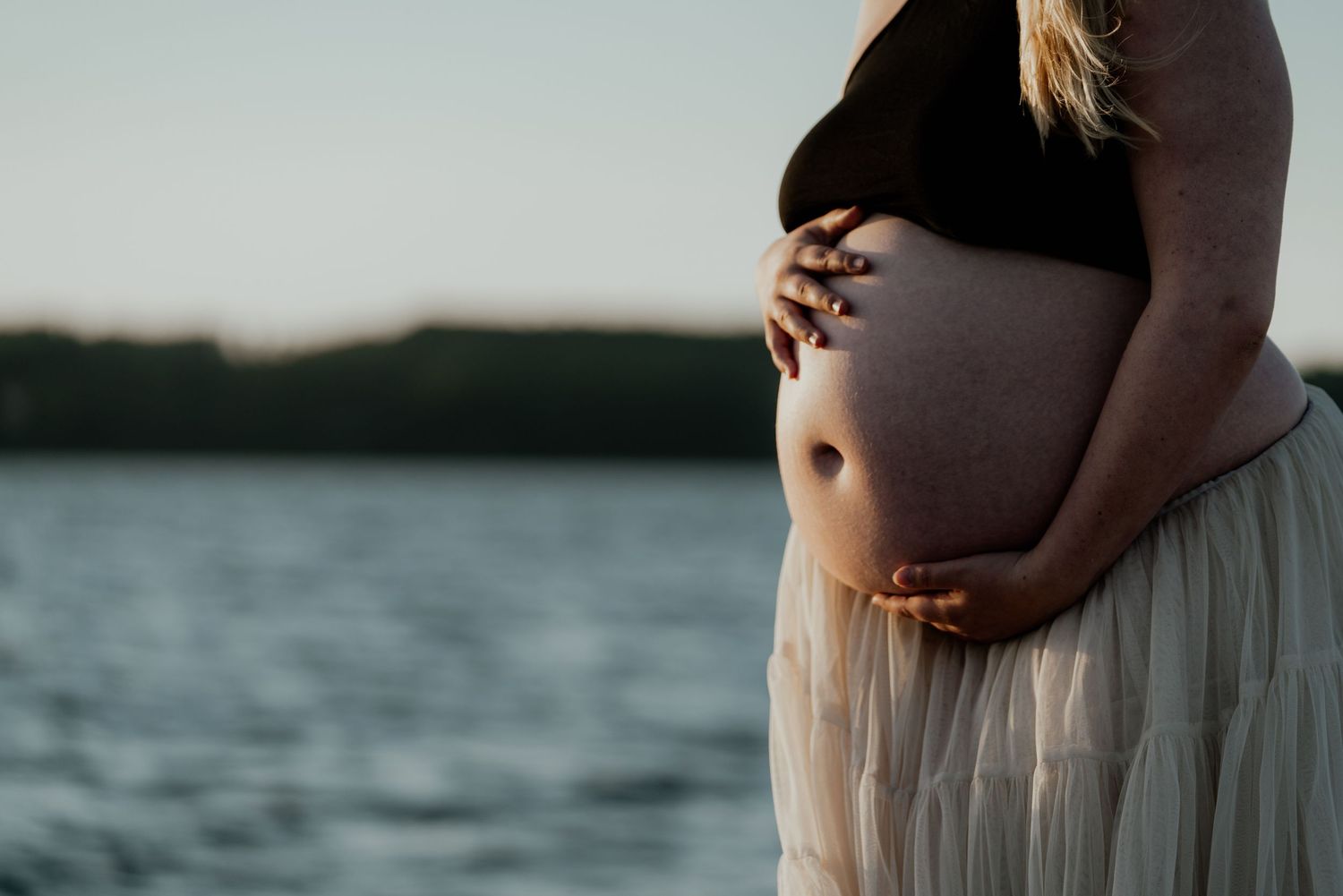 Gravid kvinde holder om maven med sine hænder