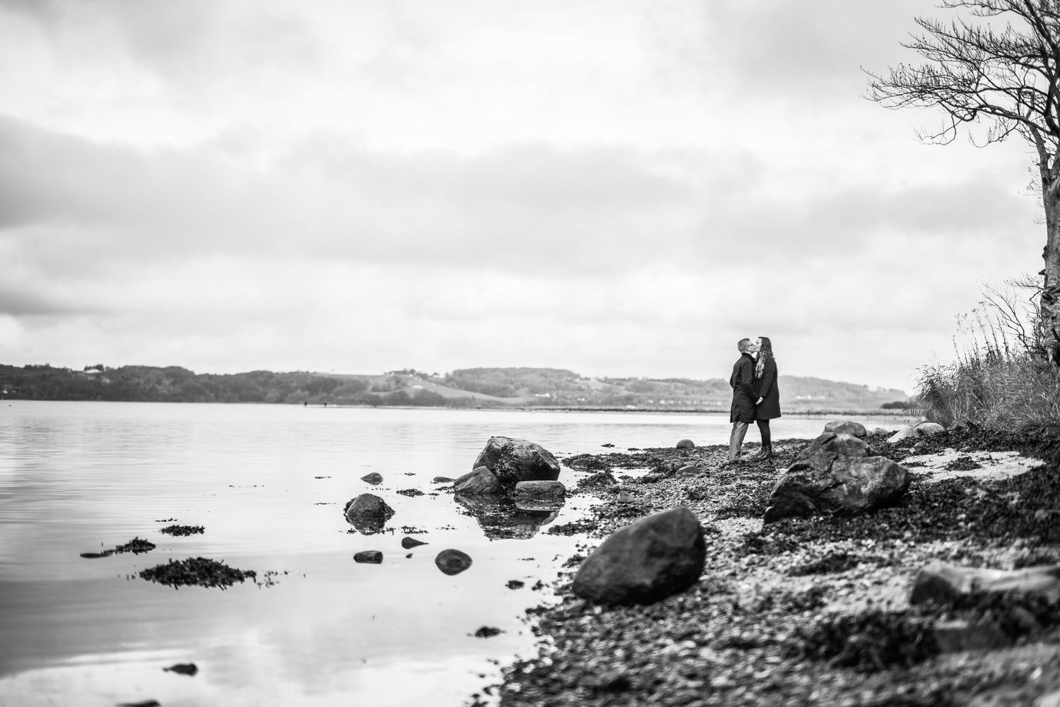 Sort-hvidt portræt af par ved vandet under deres prøvefotografering