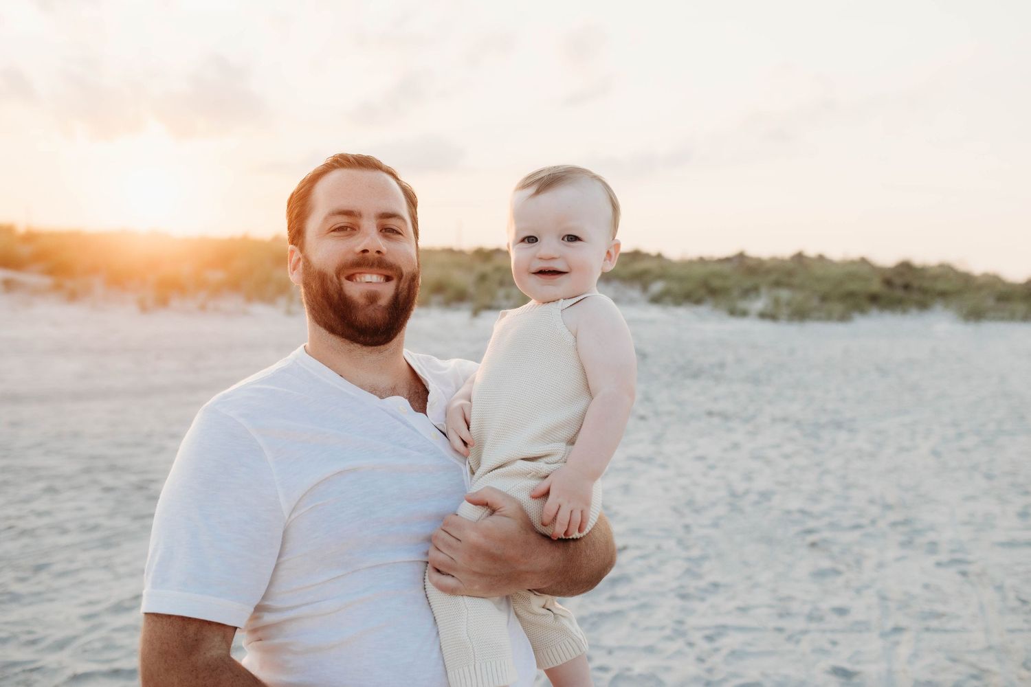A loving moment captured on a sandy beach at sunset showing a tender beachside interaction.