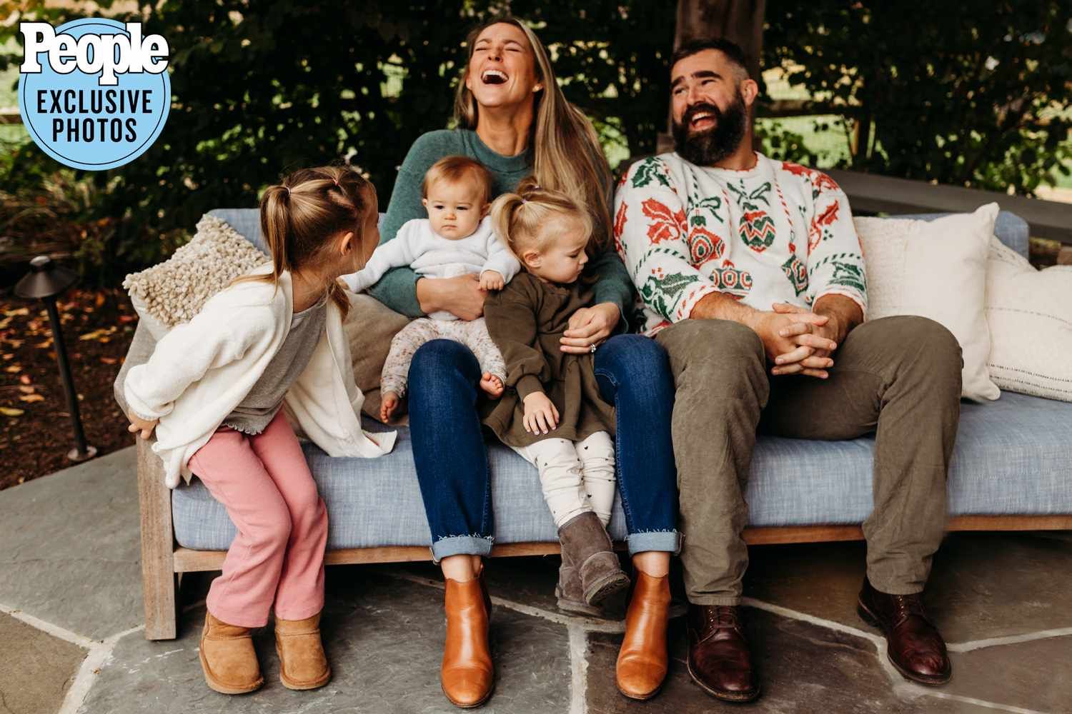 Happy family of five laughing together on outdoor sofa, featured in People magazine exclusive.