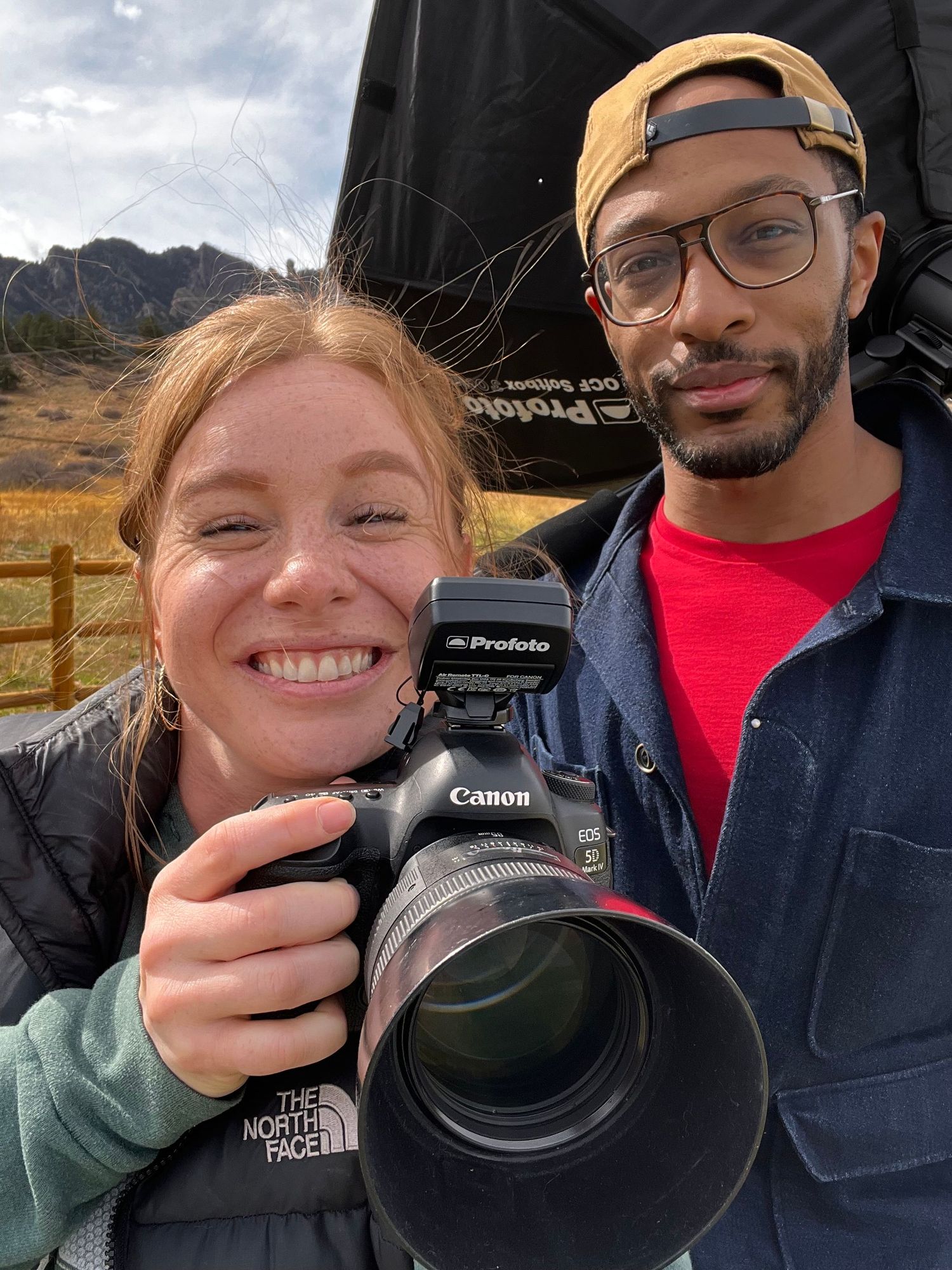 Selfie portrait of husband and wife photography team holding a camera during an outdoor session in Northern Colorado