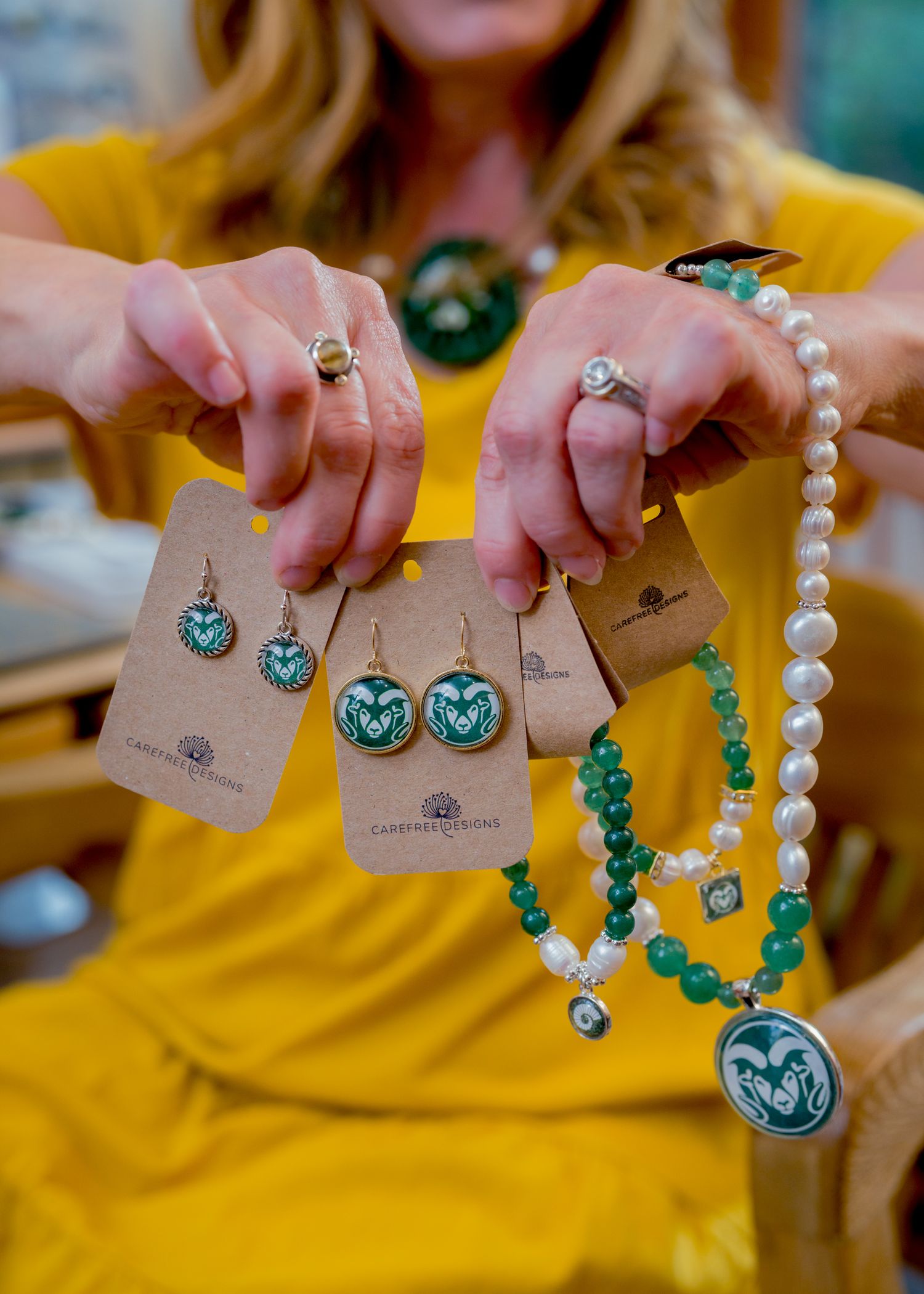 Product photography detail shot of handcrafted jewelry display cards held by artisan in Northern Colorado