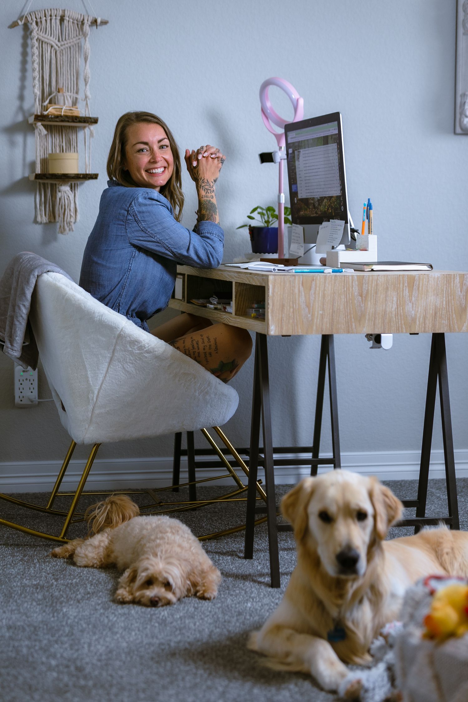 Woman working at her desk in a home office with two dogs lying on the floor during a branding session in Northern Colorado