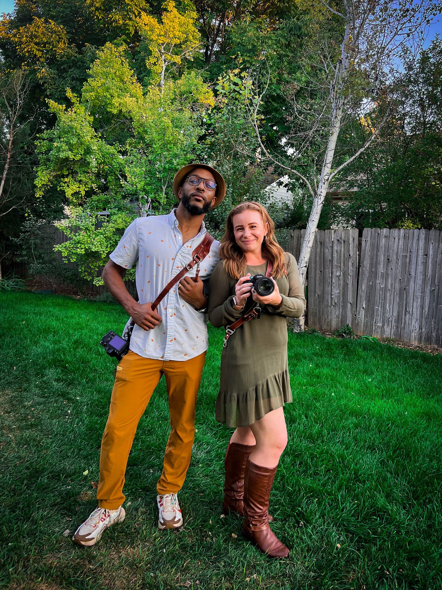 Kait and Greg of The Blended Lens posing outdoors with their cameras in Northern Colorado