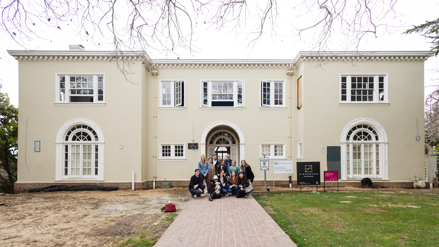 Home in Piedmont, California, with the team of the architect who is redesigning the home sitting on the front steps.