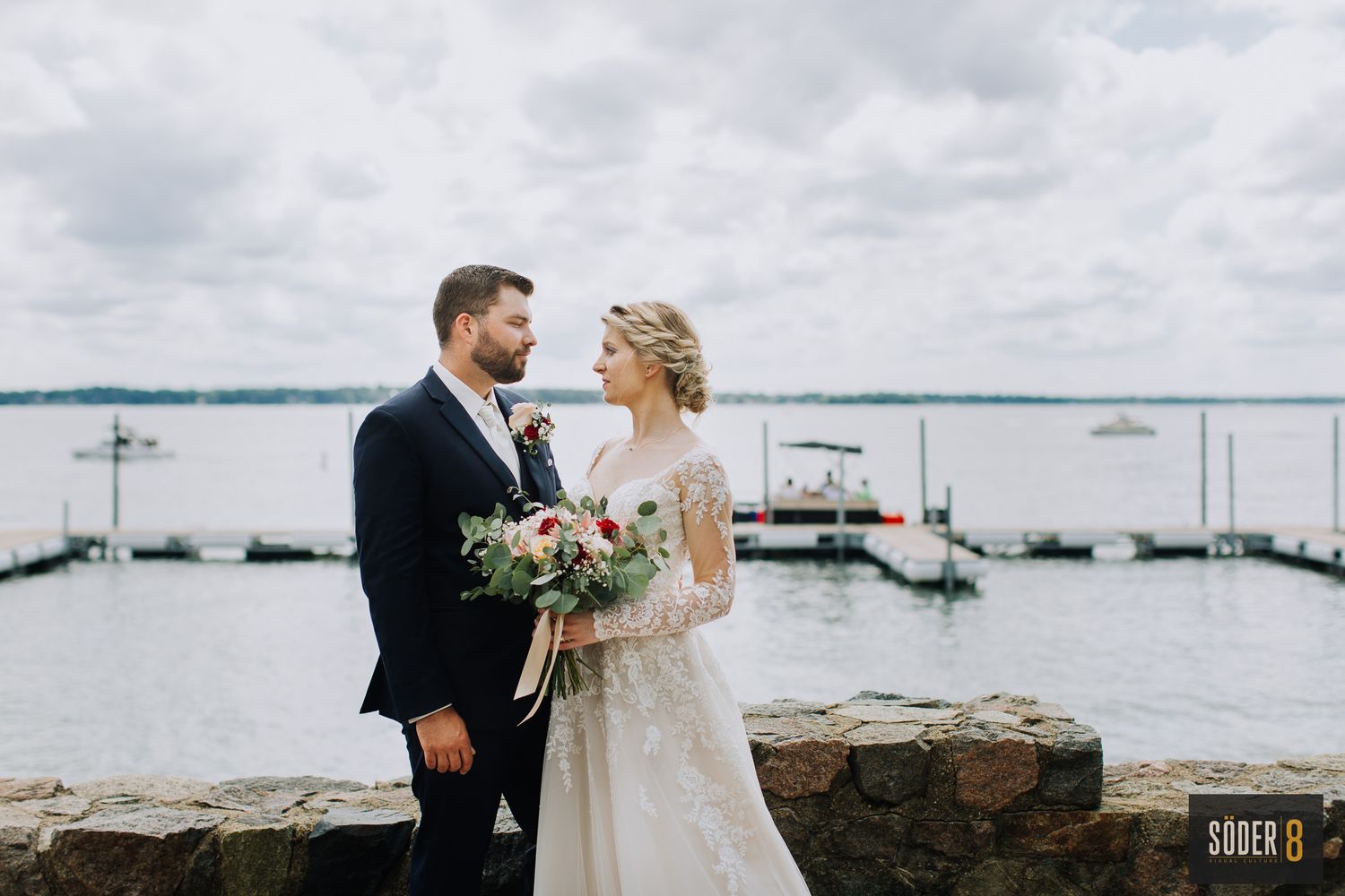 bride and groom posing on lake front in clear lake iowa