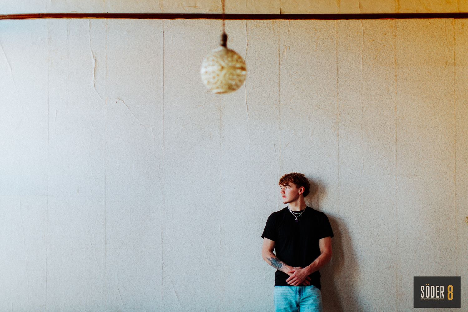 high school senior boy portrait standing against wall