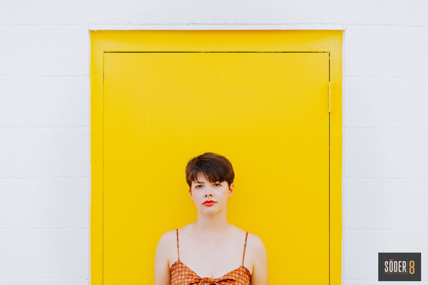 high school girl standing in front of yellow door in charles city, iowa - soder 8
