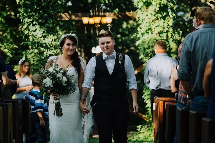 same sex couple walking down aisle after iowa ceremony