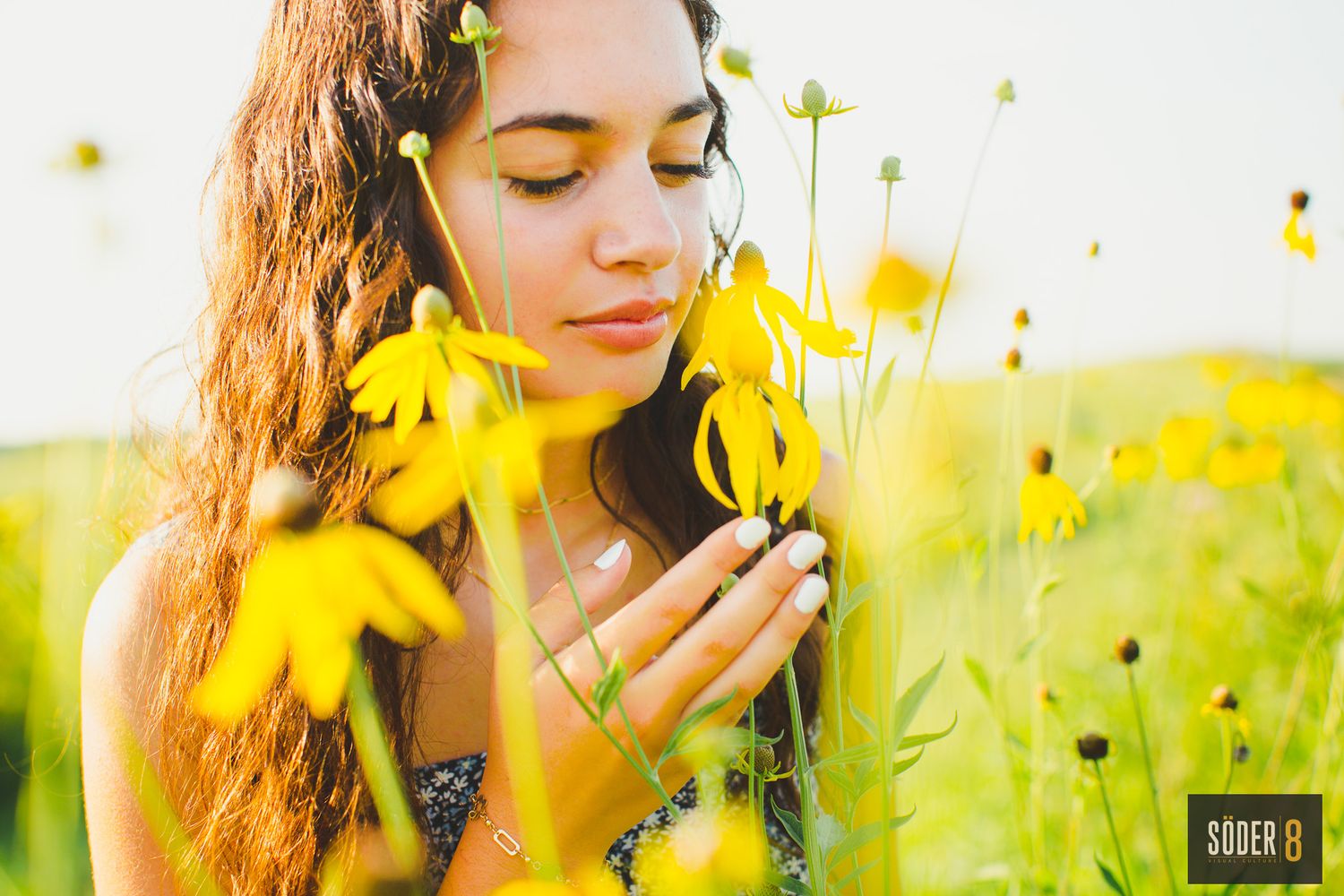 high school senior girl standing in flower garden and smelling flowers in the sun in rockford, iowa - SODER 8