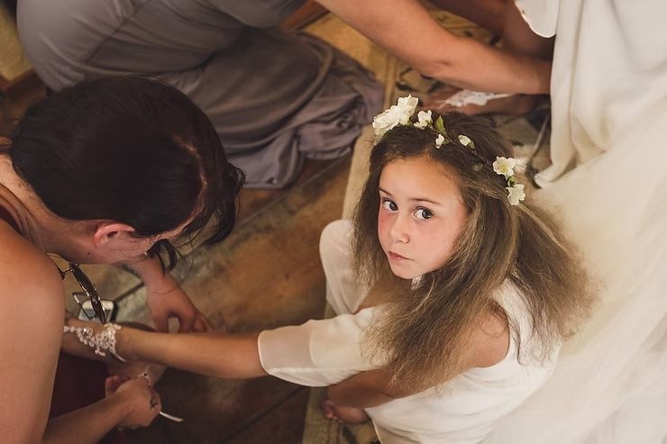 flower girl getting her shoes on before a wedding in iowa