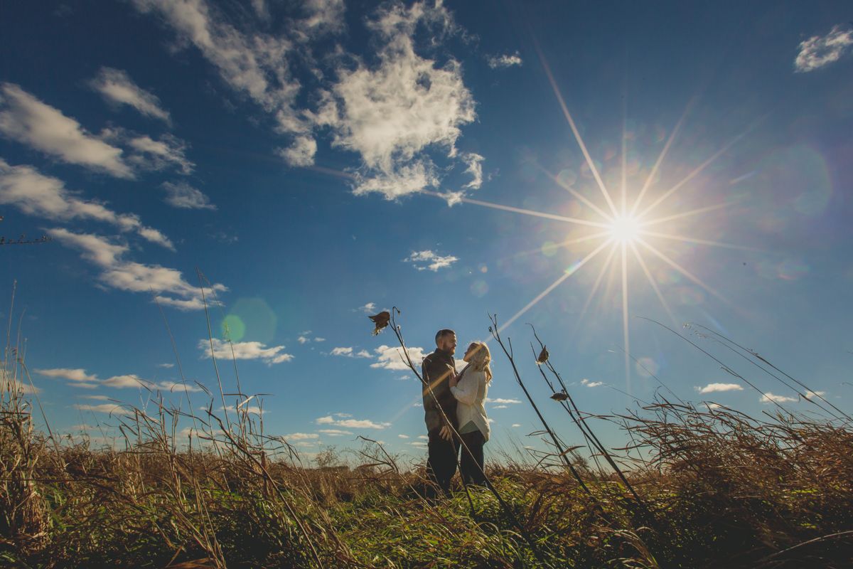 Man and woman standing in Iowa prairie for engagement photo