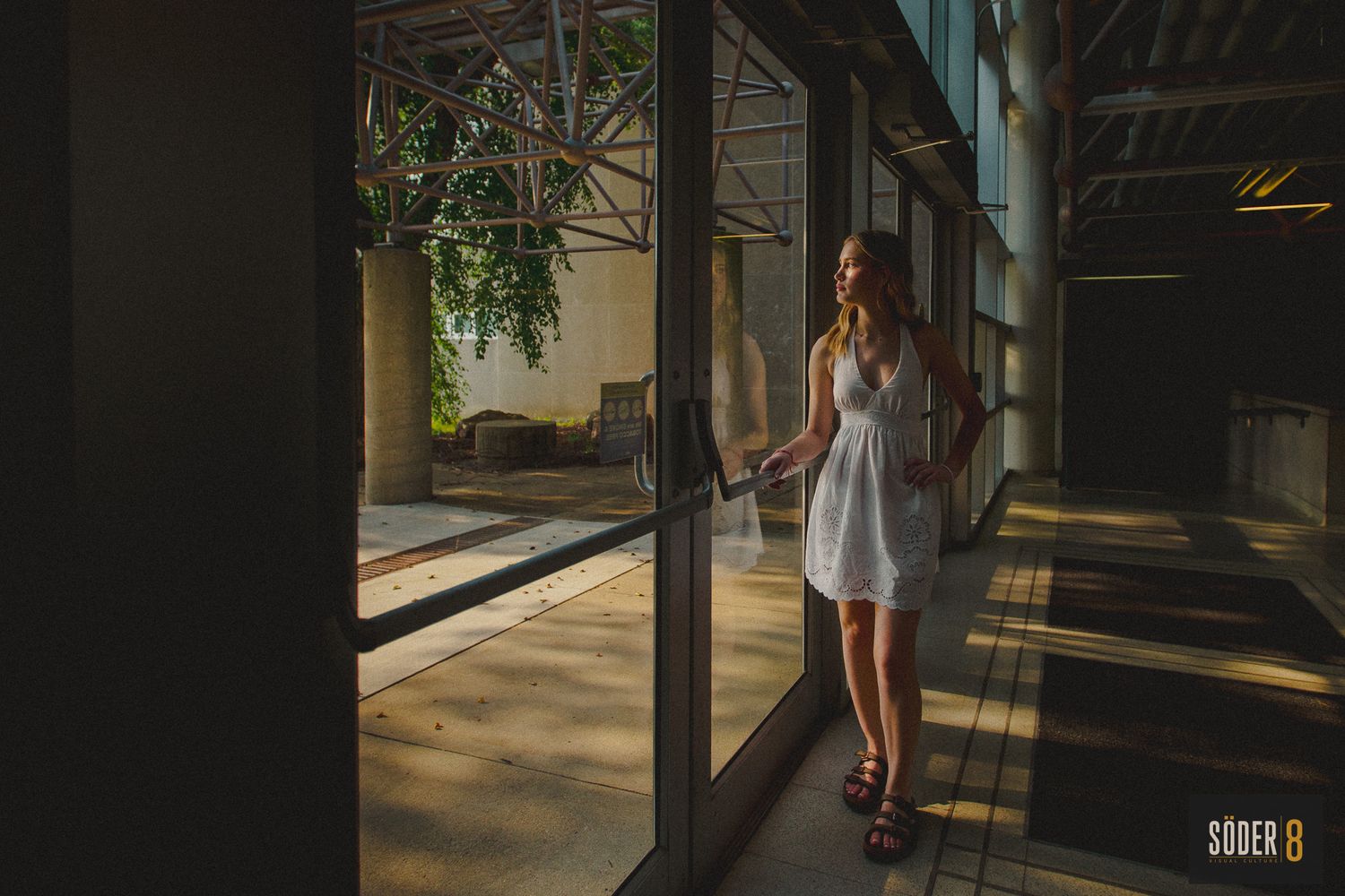 high school senior girl standing in a building looking out a window in cedar falls, iowa - soder 8