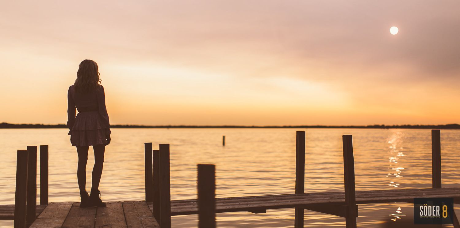 girl on pier in sunset in clear lake, iowa
