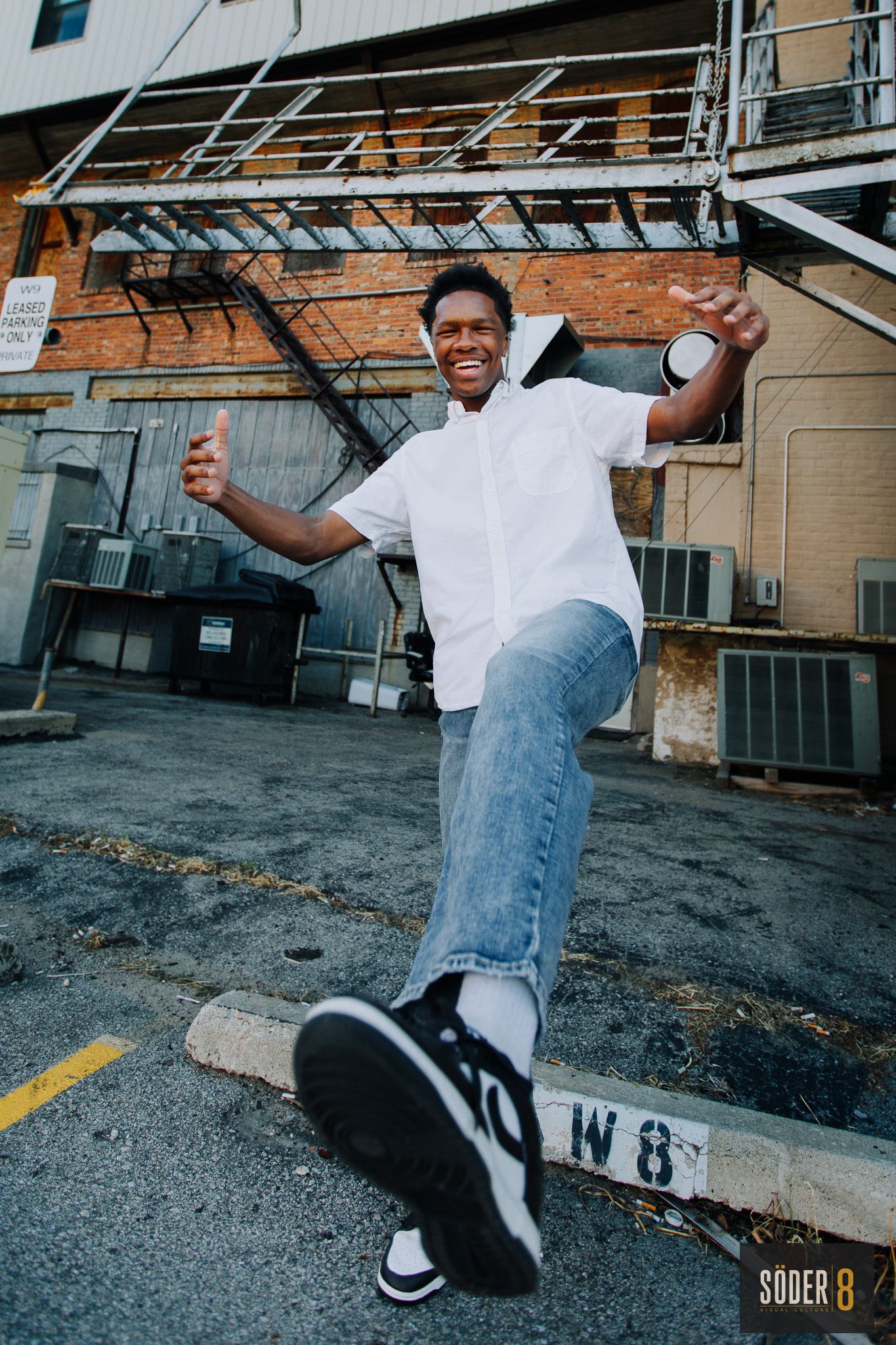 young man kicking foot up towards camera