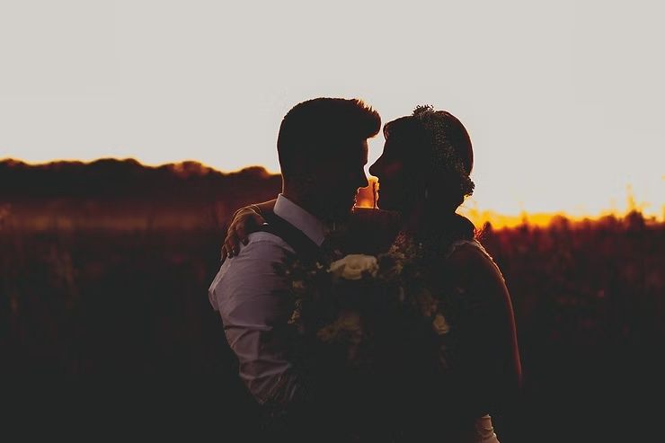same sex wedding couple hugging at sunset at diamond oak events in clear lake iowa