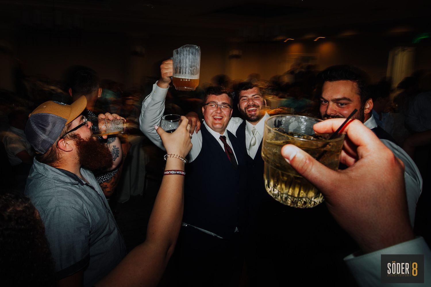 reception celebration groomsmen dancing and holding up beers