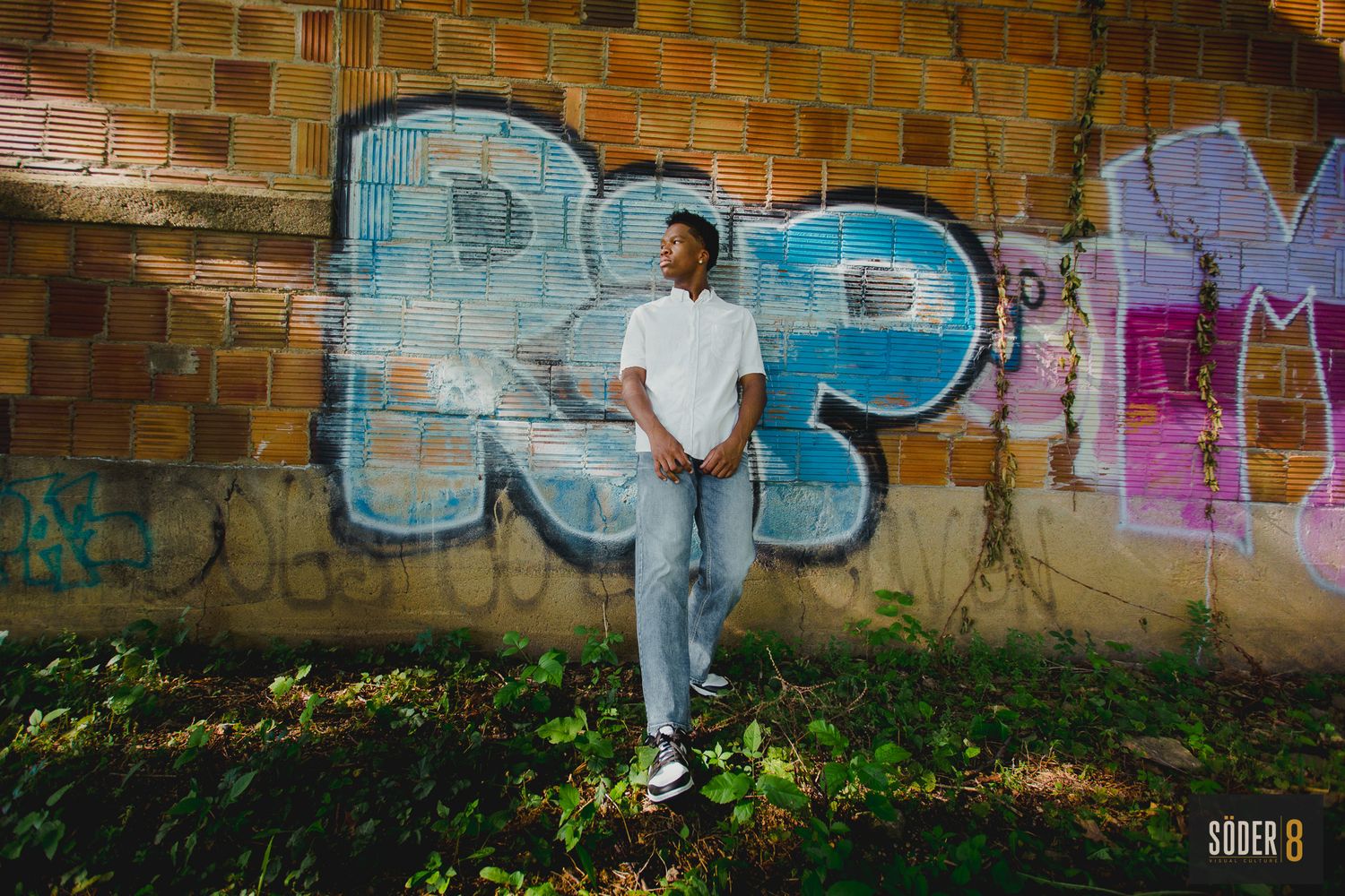 high school boy next to graffiti wall in mason city iowa
