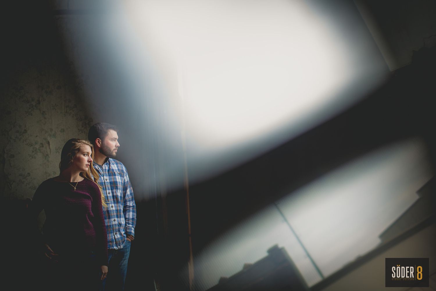 engagement couple in upstairs loft with reflection of light