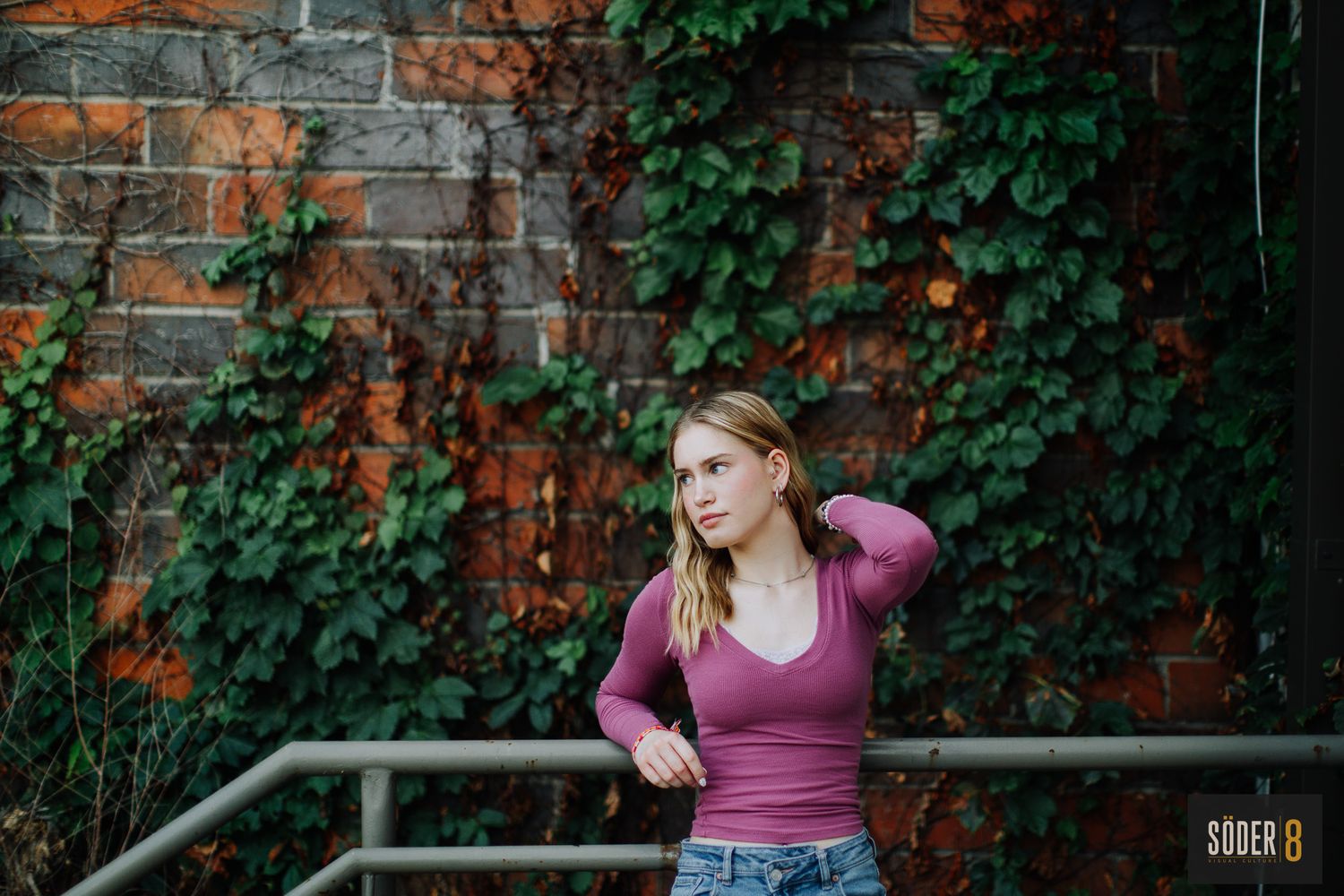 girl next to brick wall with vines in cedar falls, iowa